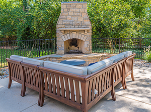 Concrete patio with stone fireplace and beige couch
