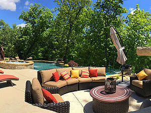 st. louis pool construction, brown wicker outdoor furniture with tan cushions, red and yellow pillows