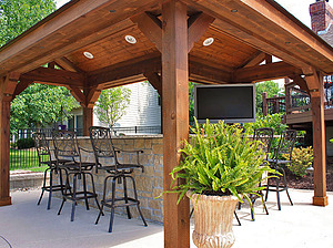 st. louis pool construction, wooden gazebo, covered outdoor kitchen with granite counter top and stone veneer, metal bar stools, tv and entertainment system