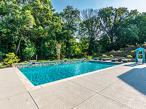 st. louis custom designed geometric concrete pool with cantilver coping and raised wall with stone veneer and scuppers