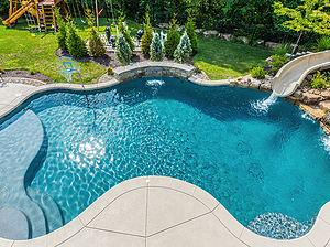 st. louis custom designed freeform concrete pool, raised wall with sheer descent, boulder water featured with fiberglass slide, basketball hoop, tan shelf