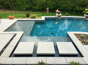 st. louis custom designed concrete pool, stone columns with fire bowls and scuppers, floating steps, cantilever coping