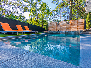 geometric st. louis custom designed concrete pool with wooden privacy fence and yellow lounge chairs