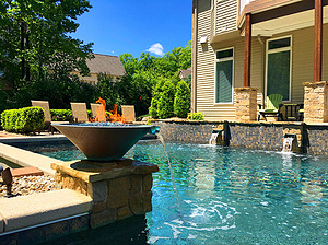 St. Louis custom design geometric concrete pool with raised tiled wall flagstone coping and stone columns with scuppers and fire water bowl