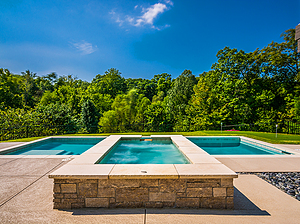 st. louis custom designed concrete pool, raised rectangular concrete spa with stone veneer and stone cap