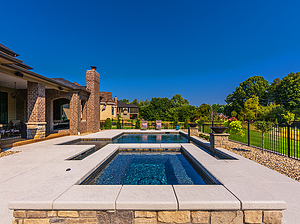 st. louis custom designed concrete pool, raised rectangular concrete spa with stone veneer and textured concrete coping