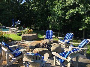 Flagstone patio with boulder fire pit and blue and beige patio furniture