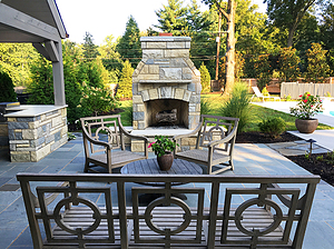 Concrete patio with stone fireplace and wood patio furniture