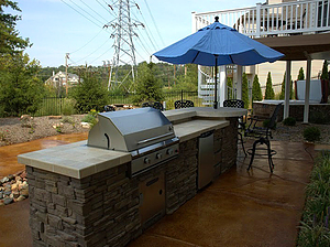 st. louis pool construction, outdoor kitchen with grill and fridge, tiled countertop with stone veneer, bar stools, colored concrete deck