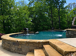 Shawnee ledgerock steps next to freeform St. Louis custom designed concrete pool with flagstone coping and exposed wall with stone veneer and fire water bowls