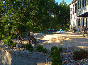 Modular block retaining wall supporting patio with concrete steps and St. Louis custom designed concrete pool