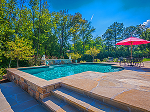 St. louis custom designed concrete pool with exposed wall, flagstone steps and patio