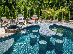 st. louis custom designed freeform concrete pool with in-pool table, concrete stools and fire water bowl