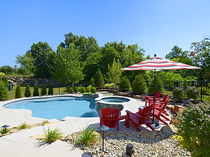 st. louis custom designed freeform concrete pool, raised concrete spa, red patio furniture