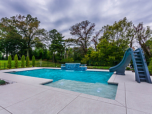 st. louis custom designed geometric concrete pool with cantilever coping, raised tiled wall with sheer descent, slide and tan shelf