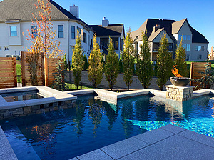 st. louis custom designed geometric concrete pool with privacy panels, raised concrete spa, cantilever coping and stone column with fire bowl