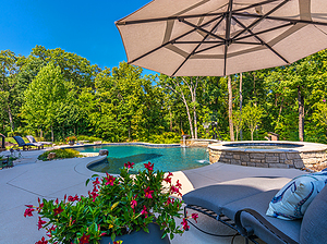 freeform st. louis custom designed concrete pool with spa and plush patio furniture