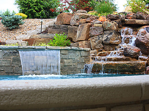 St. Louis custom designed concrete pool with textured cantilever coping, large boulder water feature and raised concrete spa with sheer descent