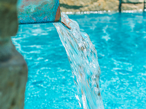 St. Louis custom designed concrete pool with raised wall with stone veneer, flagstone coping and copper scupper