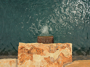 Looking down on St. Louis custom designed geometric concrete pool with stone columns with flagstone coping and copper scupper