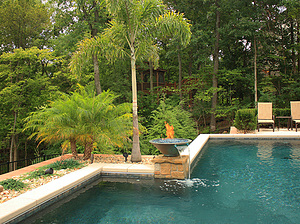St. Louis custom designed geometric concrete pool with cantilever coping and stone column with fire water bowl