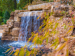 St. Louis custom designed concrete pool with grotto and larger boulder water feature