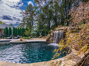 St. Louis custom designed freeform concrete pool with flagstone coping, grotto and large boulder water feature