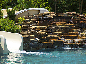 St. Louis custom designed concrete pool with slide and large boulder water feature