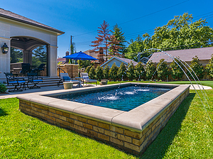 St. Louis custom designed geometric concrete pool with exposed walls with stone veneer, cast stone coping and three water crystal jets