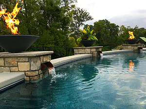 St. Louis custom designed concrete pool with textured coping and stone columns with copper scuppers, fire bowls and planter pot
