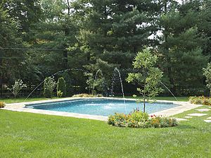 St. Louis custom designed geometric concrete pool with grass deck, stone coping and corner laminar jets