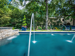 Geometric St. Louis custom designed concrete pool with raised stone wall, sheer descent and water crystal jets