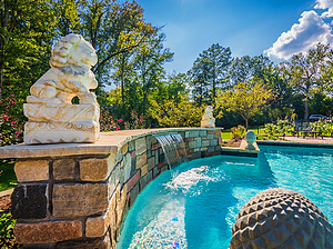 St. Louis custom designed concrete pool with raised wall with stone veneer, flagstone coping, sheer descent and lion statues