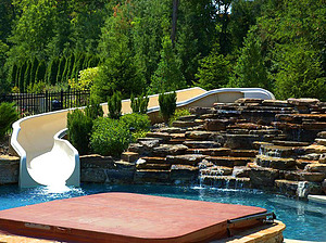 st. louis custom designed concrete pool with fiberglass water slide and boulder waterfall water feature