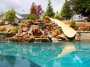 st. louis custom designed concrete pool with fiberglass water slide and boulder waterfall water feature