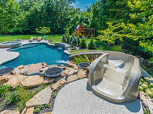 freeform st. louis custom designed concrete pool with fiberglass water slide and fire bowls