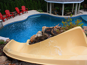 freeform st. louis custom designed concrete pool with fiberglass water slide, gazebo structure and red patio furniture
