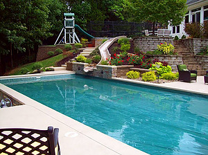 geometric st. louis custom designed concrete pool with fiberglass water slide and colorful landscaping
