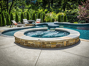 st. louis custom designed freeform concrete pool, raised concrete spa with stone veneer and flagstone cap