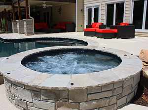 st. louis custom designed freeform concrete pool, raised concrete spa with stone veneer and flagstone cap