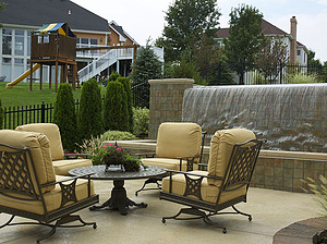 concrete patio with table and beige chairs